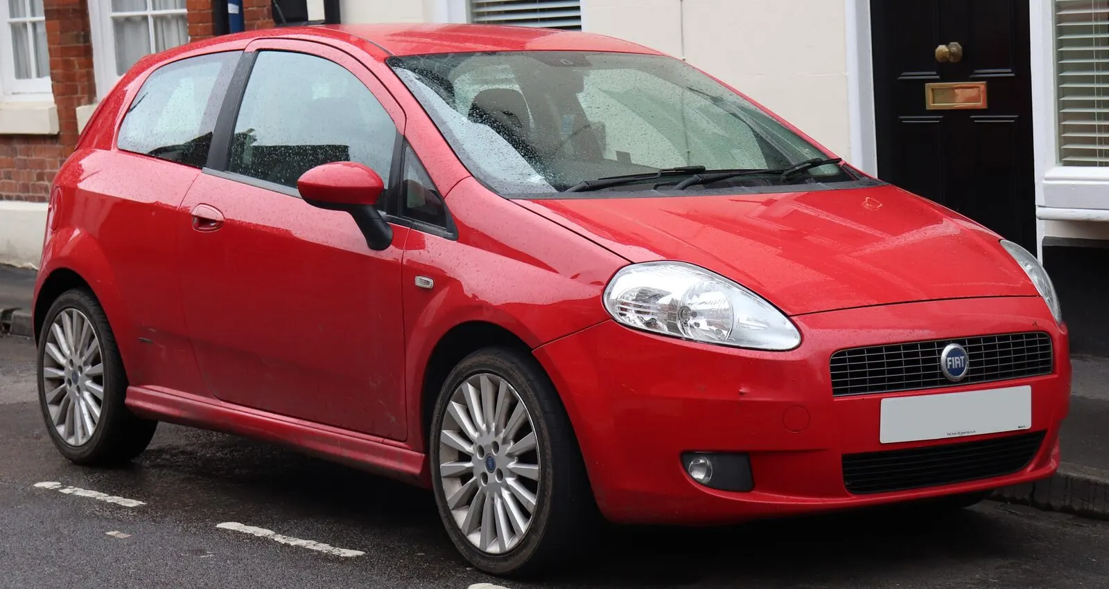 Fiat Grande Punto Sport T-Jet (2006.) s troje vrata u crvenoj boji, pogled sprijeda sa strane