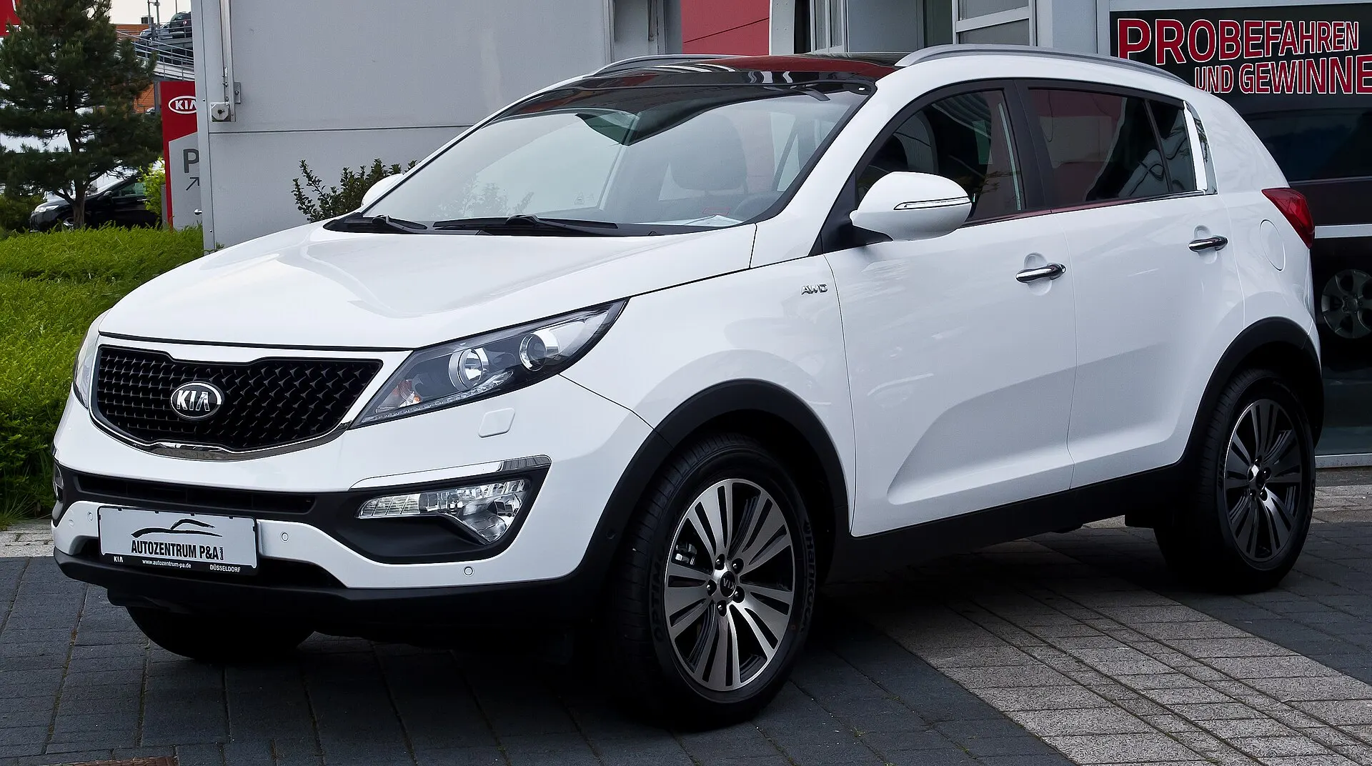Kia Sportage treće generacije (SL, facelift) u bijeloj boji, pogled sprijeda sa strane