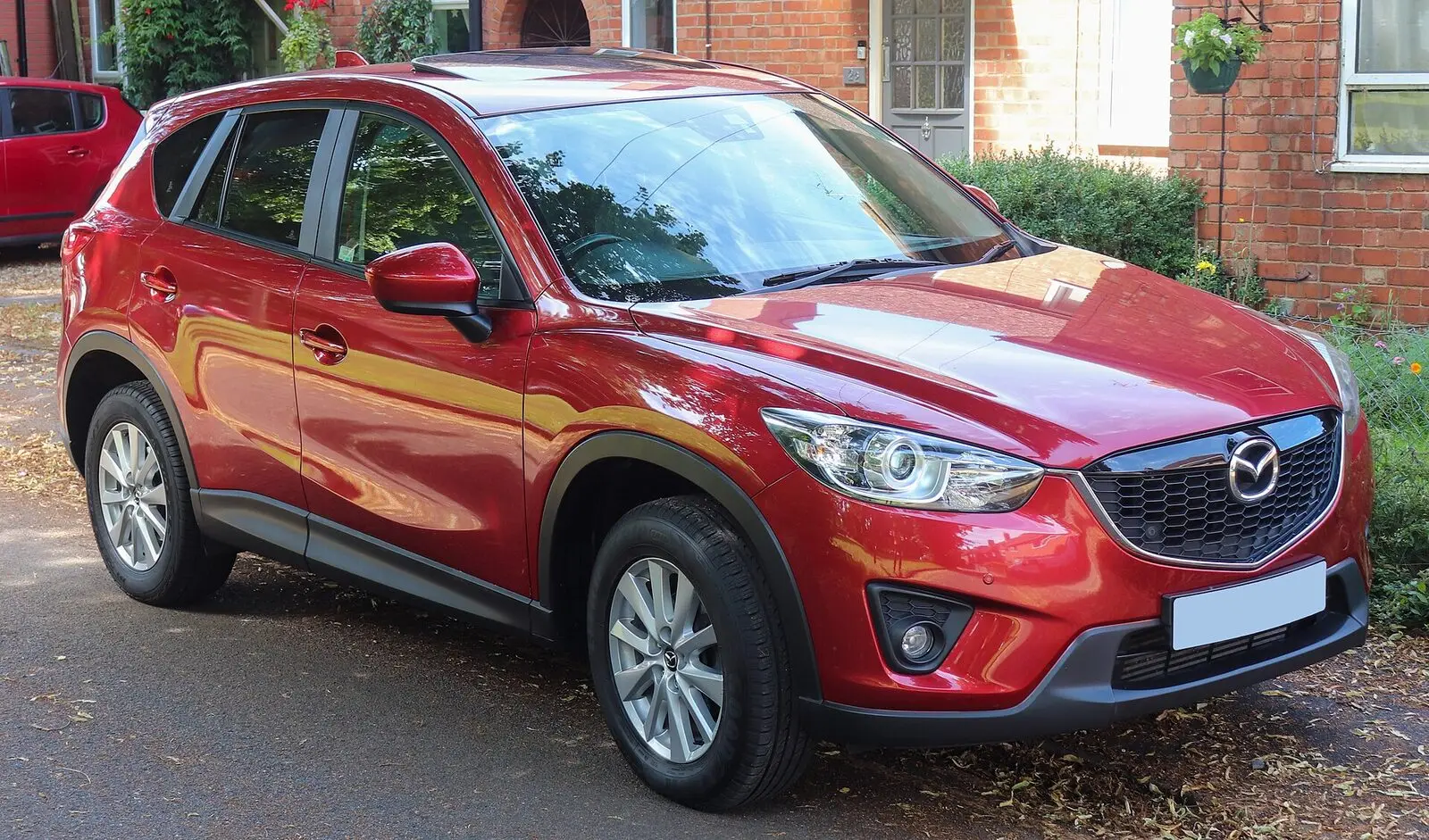 Mazda CX-5 prve generacije (2014.) u crvenoj boji, pogled sprijeda sa strane