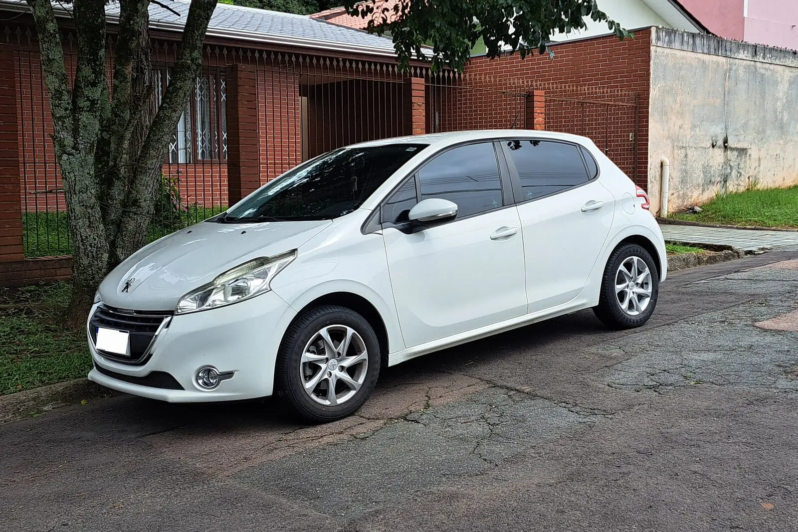 Peugeot 208 prve generacije u bijeloj boji s pet vrata, pogled sprijeda sa strane