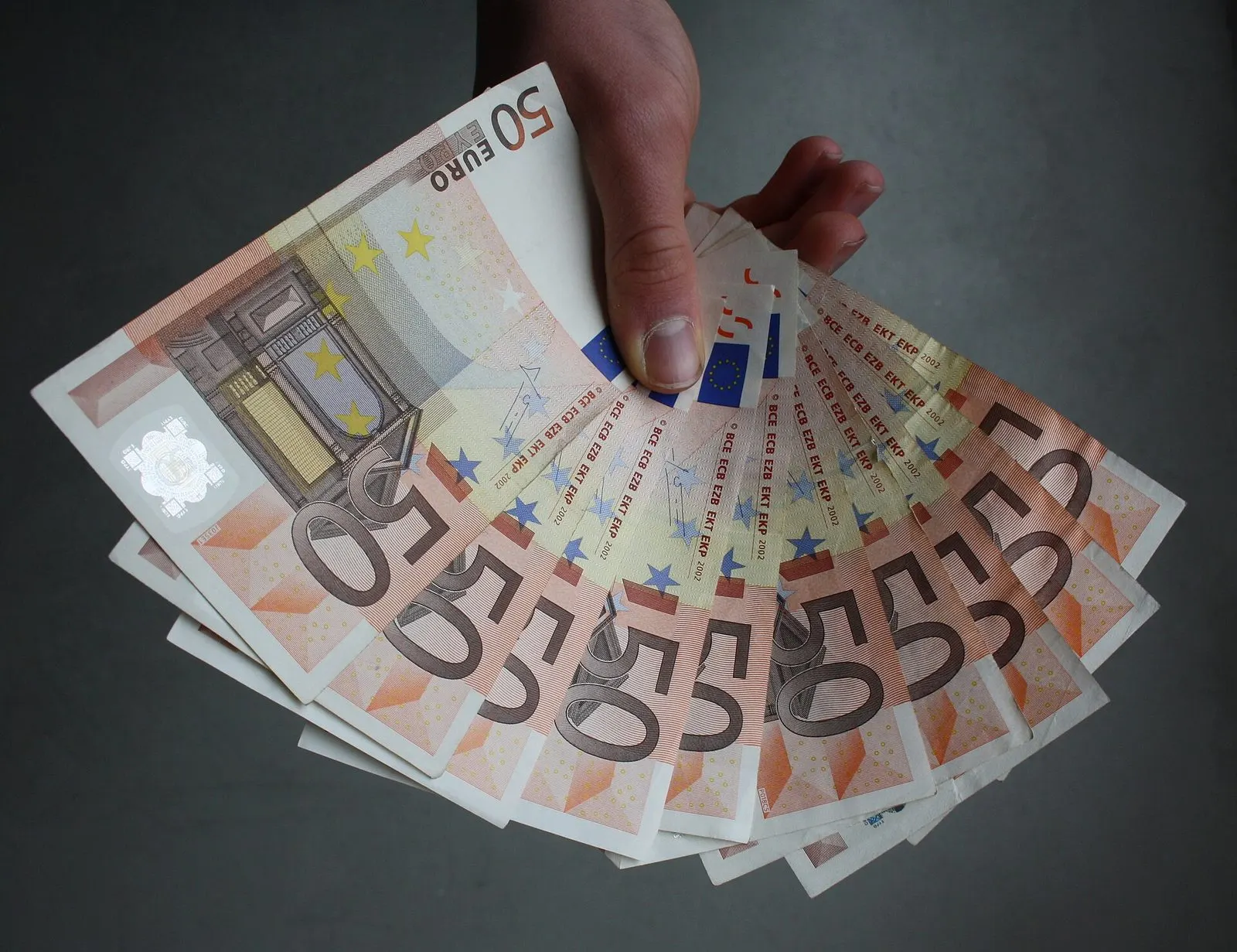 Ruka drži lepezu novčanica od 50 eura