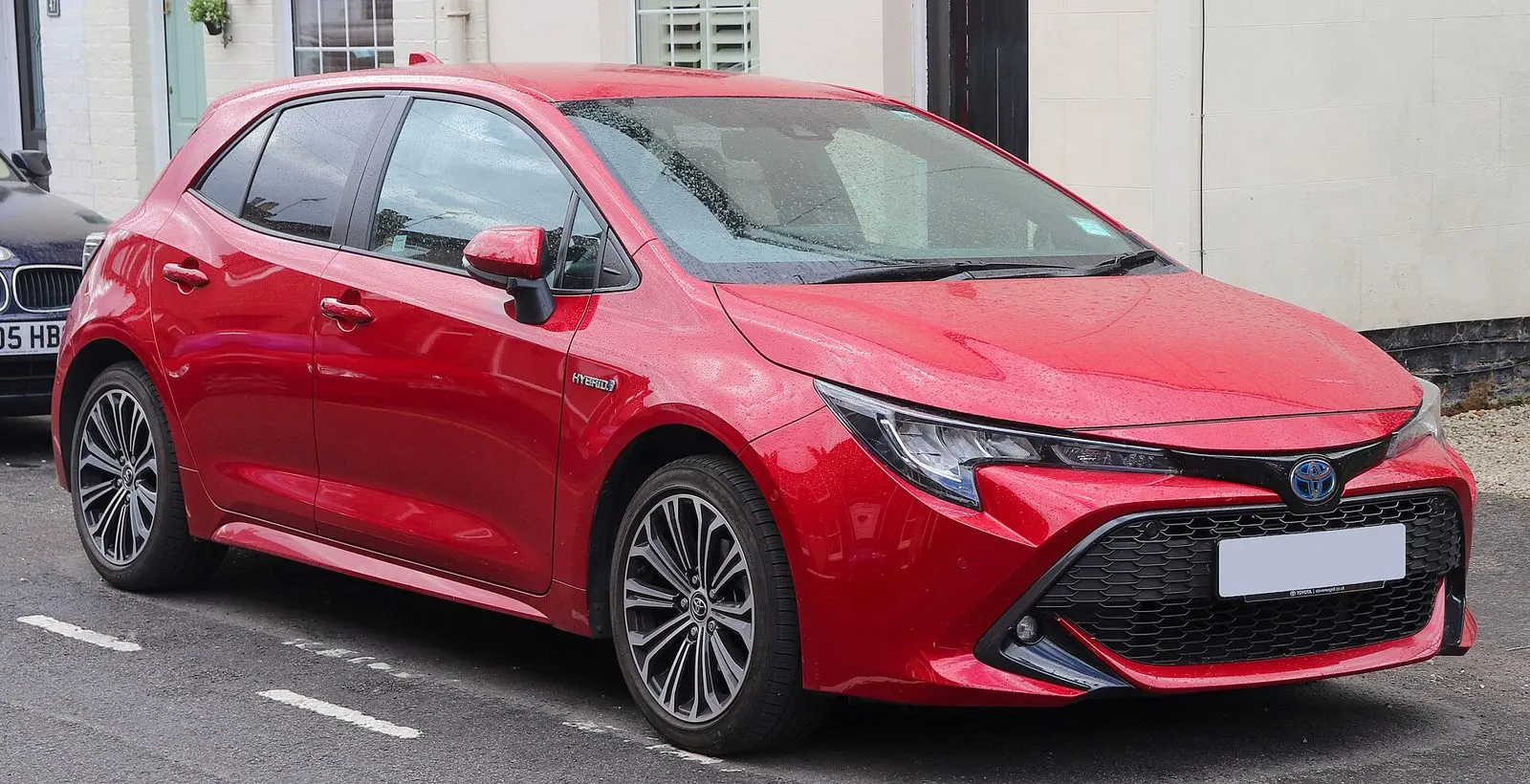 Toyota Corolla E210 Hybrid hatchback u crvenoj boji, pogled sprijeda sa strane