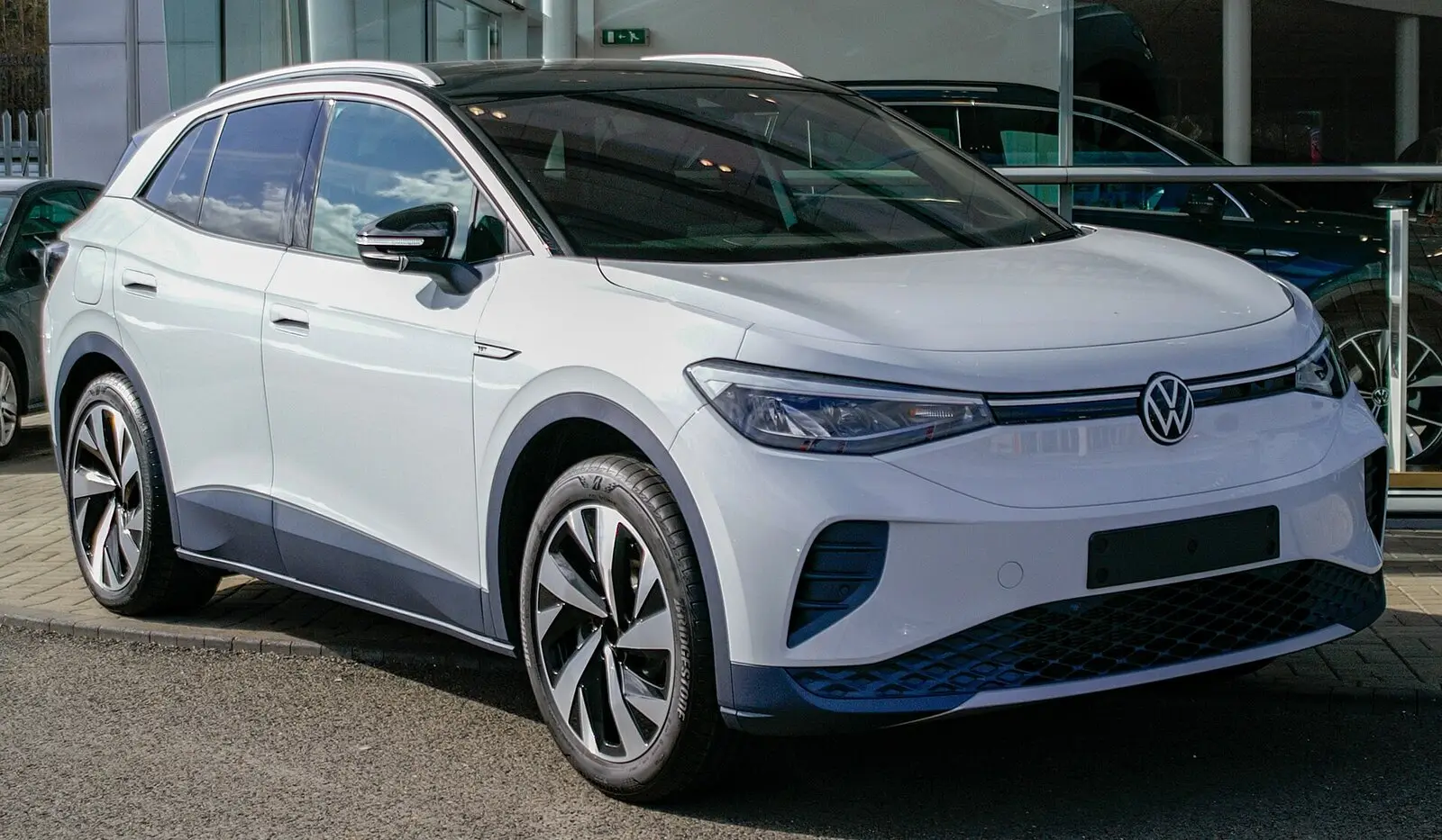Volkswagen ID.4 (2021.) u bijeloj boji sa srebrnim krovnim lukom, pogled sprijeda sa strane