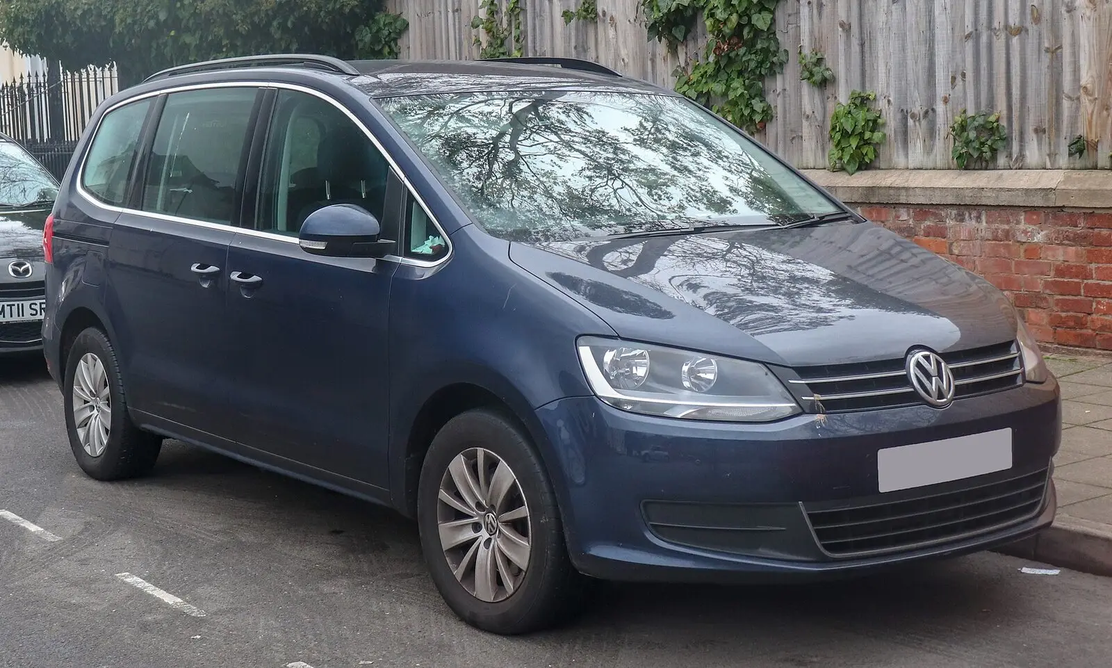 Volkswagen Sharan II SE BlueMotion (2014.) u tamnoplavoj boji, pogled sprijeda sa strane
